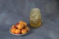 A mug of juice with ice and a plate with apricots and peaches