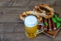 Mug of light beer, fresh pretzels and fried sausages for snack one day of October fest Royalty Free Stock Photo