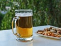 Mug of light beer and peanuts on the table Royalty Free Stock Photo