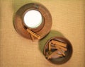 A mug of milk, a saucer and a bowl of cinnamon are on a table covered with burlap. Top view. Pottery on the table