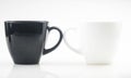 Mug mock up. Two ceramic mugs on white background. Blank coffee or tea mugs. Black cup and white cup. Copy space Royalty Free Stock Photo