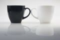 Mug mock up. Two ceramic mugs on white background. Blank coffee or tea mugs. Black cup and white cup. Copy space Royalty Free Stock Photo