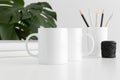 Mug mockup with workspace accessories and a monstera plant
