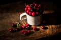 Mug with sweet red cherries on table
