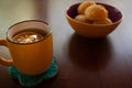 A mug of tea and a bowl of cheese buns.