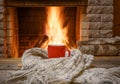 A mug of tea and woolen thing near a cozy fireplace, in a country house, winter or autumn holidays