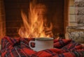 A mug of tea and woolen thing near a cozy fireplace, in a country house, winter or autumn holidays