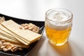 Mug of unfiltered light wheat beer with beer snacks on white table Royalty Free Stock Photo