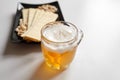 Mug of unfiltered light wheat beer with beer snacks on white table Royalty Free Stock Photo