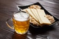 Mug of unfiltered light wheat beer with beer snacks on wooden table Royalty Free Stock Photo