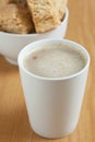 A mugg of coffee with a bowl of rusks in the background Royalty Free Stock Photo
