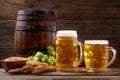 Mugs of beer with green hops and wheat ears Royalty Free Stock Photo