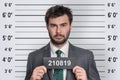 Mugshot of man in suit at police station