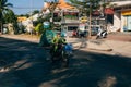 MUI NE, VIETNAM - CIRCA MARCH 2017: Elderly woman riding a motorbike and carries empty bottles
