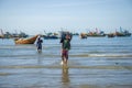 Vietnamese fisherman carries a catch from a boat to the shore