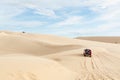 Mui Ne, Vietnam - June 2019: off-road car driving through desert sand dunes at sunrise