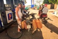 Asian Man at Gas Station Refuels Motorbike and Tanks