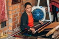 MUI NE, VIETNAM - MARCH 6, 2017: A woman weaver at a traditional loom for yarn silk Royalty Free Stock Photo