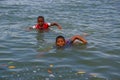 Muisne, Ecuador - March 16, 2016: Kids swimming in pacific ocean from stone surface with clothes on