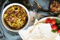 Mujadara: lentils and rice pilaf with fried onions and pita on light background.