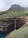 Mulafossur Waterfall pours over the cliffs from Gasadalur