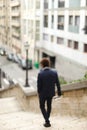 Mulatto guy walking down steps with newspaper. Royalty Free Stock Photo