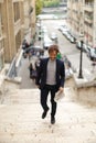 Mulatto guy walking down steps with newspaper. Royalty Free Stock Photo