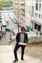 Mulatto guy walking down steps with newspaper. Royalty Free Stock Photo