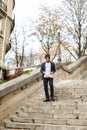 Mulatto guy walking down steps with newspaper. Royalty Free Stock Photo