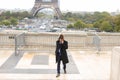 Mulatto laughing guy around Eiffel Tower with smartphone