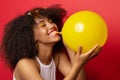 Mulatto model inflates a yellow balloon