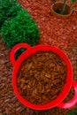 Mulching soil cover made of natural materials.Decorative chips for the garden.Red chips for mulching in red silicone Royalty Free Stock Photo