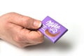 Mini chocolate bar by milka compagny in hand on white background