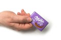 Mini chocolate bar by milka compagny in hand on white background