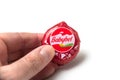 One mini babybel cheese in hand on white background