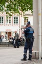 Portrait of french municipal policeman standing on main place with telephone in hand