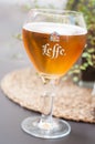 Closeup of glass of beer from Leffe brand on the table of restaurant terrace