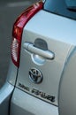 Closeup of logo, handle and rear light on grey Toyota rav4 parked in the street