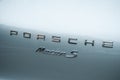 Closeup of Porsche Macan S logo on blue rear car