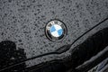 Closeup of rain dropds on BMW sign front of blck car parked in the street Royalty Free Stock Photo