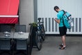 Delivery man waiting with smartphone near restaurant, deliveroo is a british delivery company in mountain bike Royalty Free Stock Photo