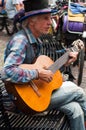 Portrait of old man playing acoustic guitar in the street