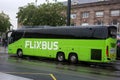 Profile view of green flixbus parked in front of the train station in the street