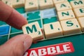 Closeup of plastic letters M in hand for formaing a word on Scrabble board game Royalty Free Stock Photo