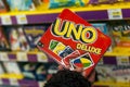 Uno game cards in hand of woman in a toy store supermarket Royalty Free Stock Photo