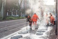 Workers repair the cobblestone with asphalt in the street Royalty Free Stock Photo