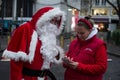 portrait of man wearing a santa claus costume giving his phone number at the christmas