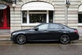 Profile view of black Mercedes e400 d parked in the street by rainy day