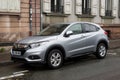 Profile view of grey Honda SUV parked in the street by rainy day