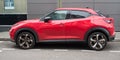 Profile view of red Nissan Juke parked in the street